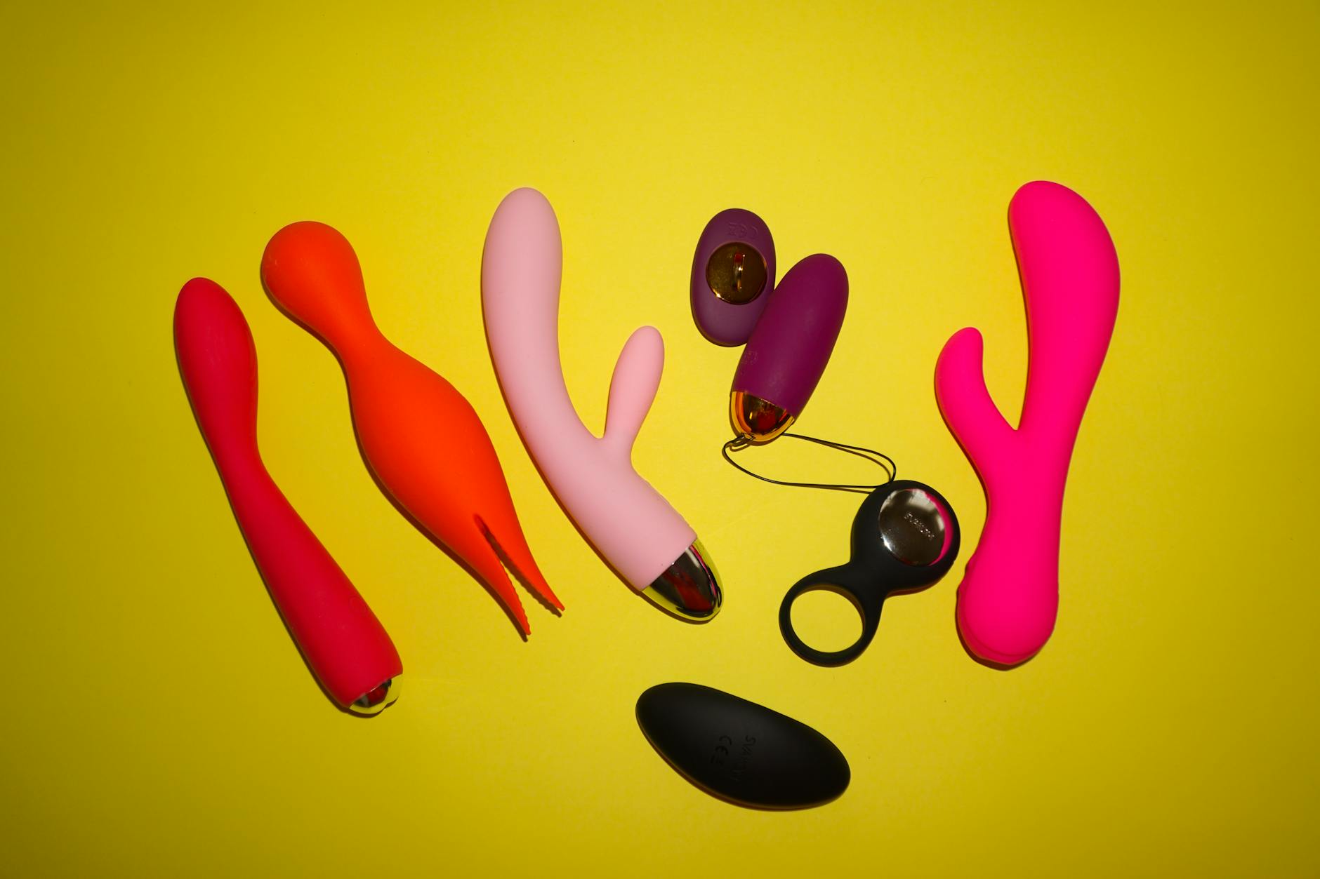 Pareja joven sostiene juntos un vibrador azul en casa, representando intimidad moderna después del parto